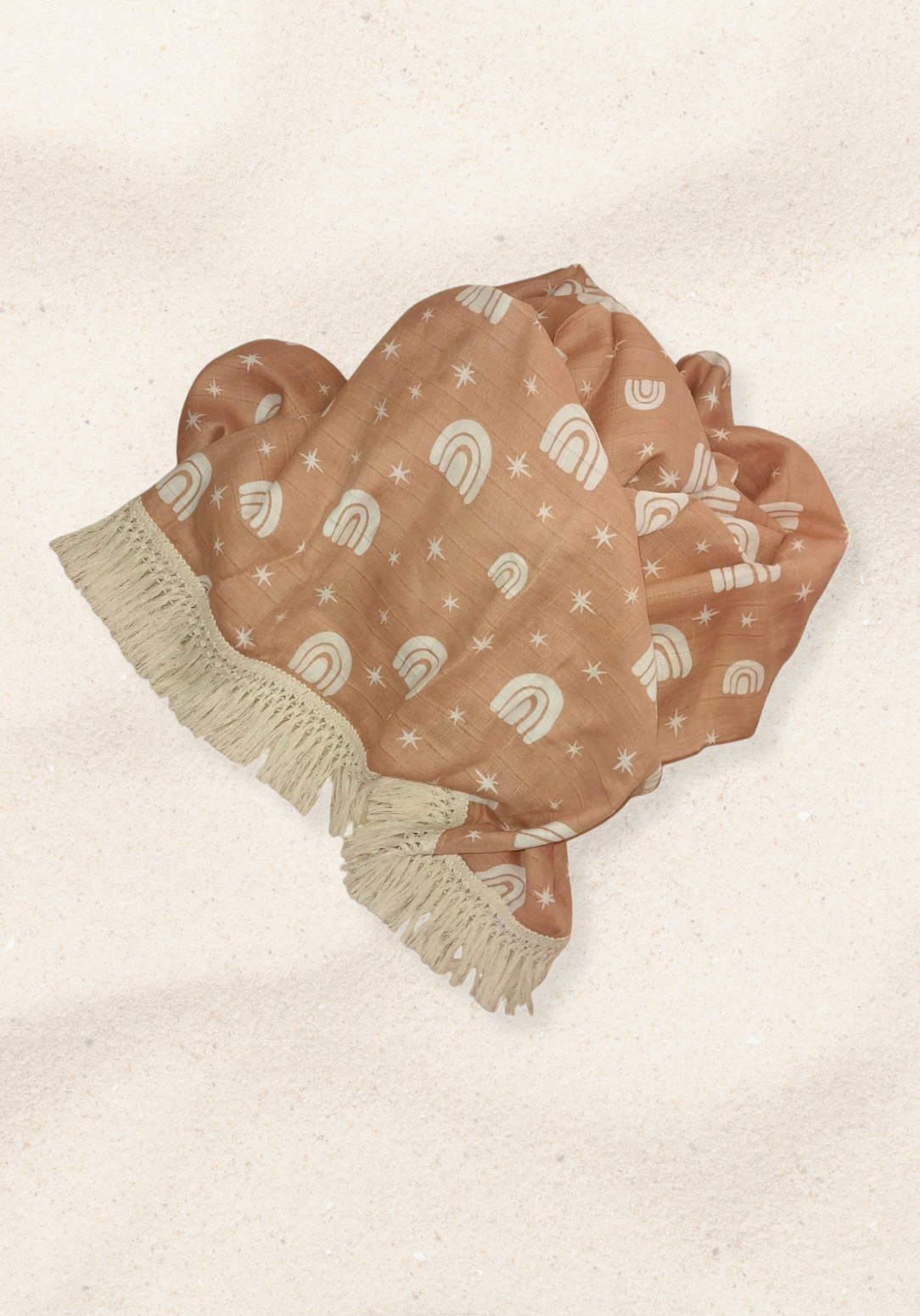 Peach baby blanket with white rainbow and star patterns, edged with cream fringe. Perfect for cozy snuggles.