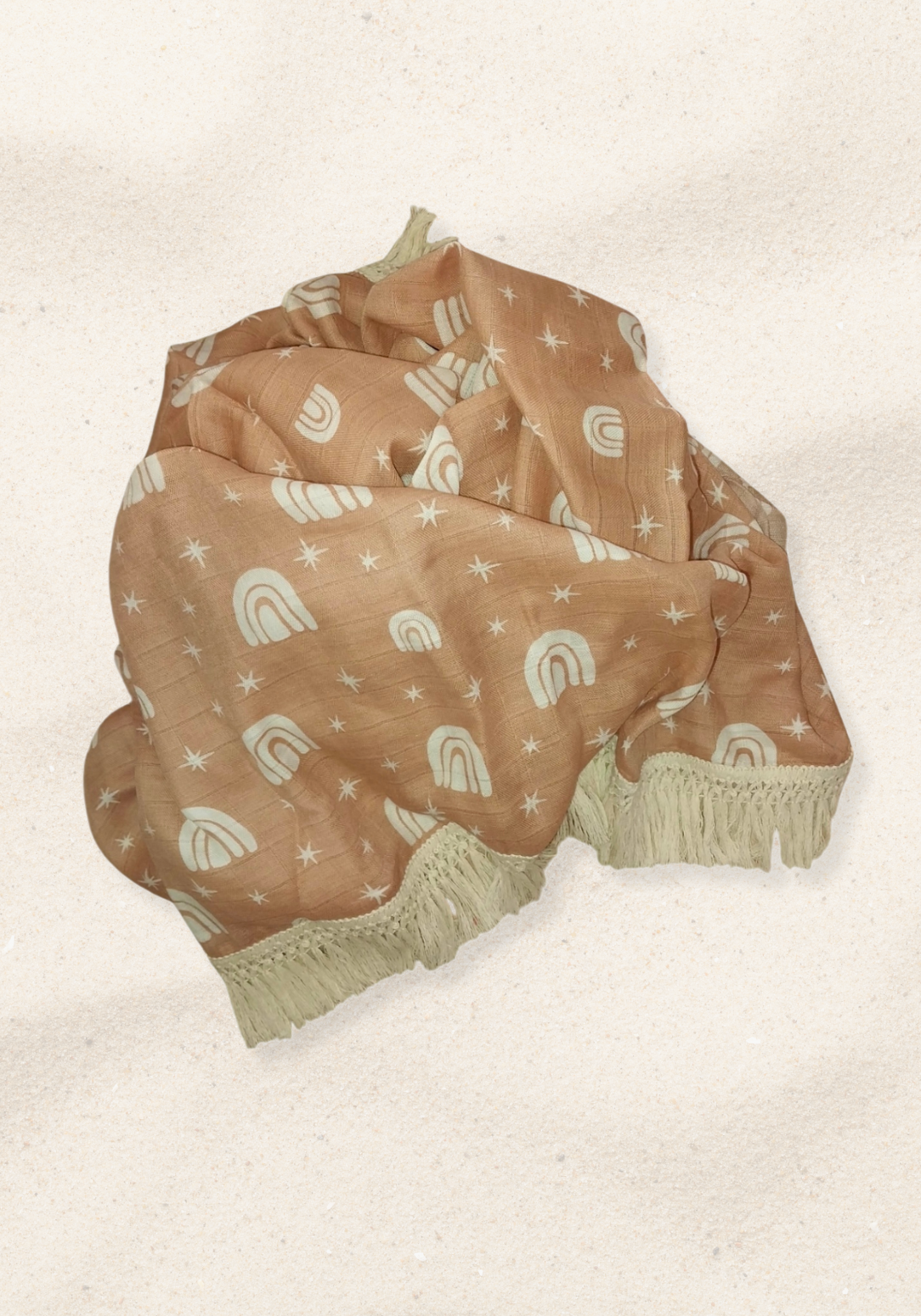Peach baby blanket with white rainbow and star patterns, edged with cream fringe. Perfect for cozy snuggles.