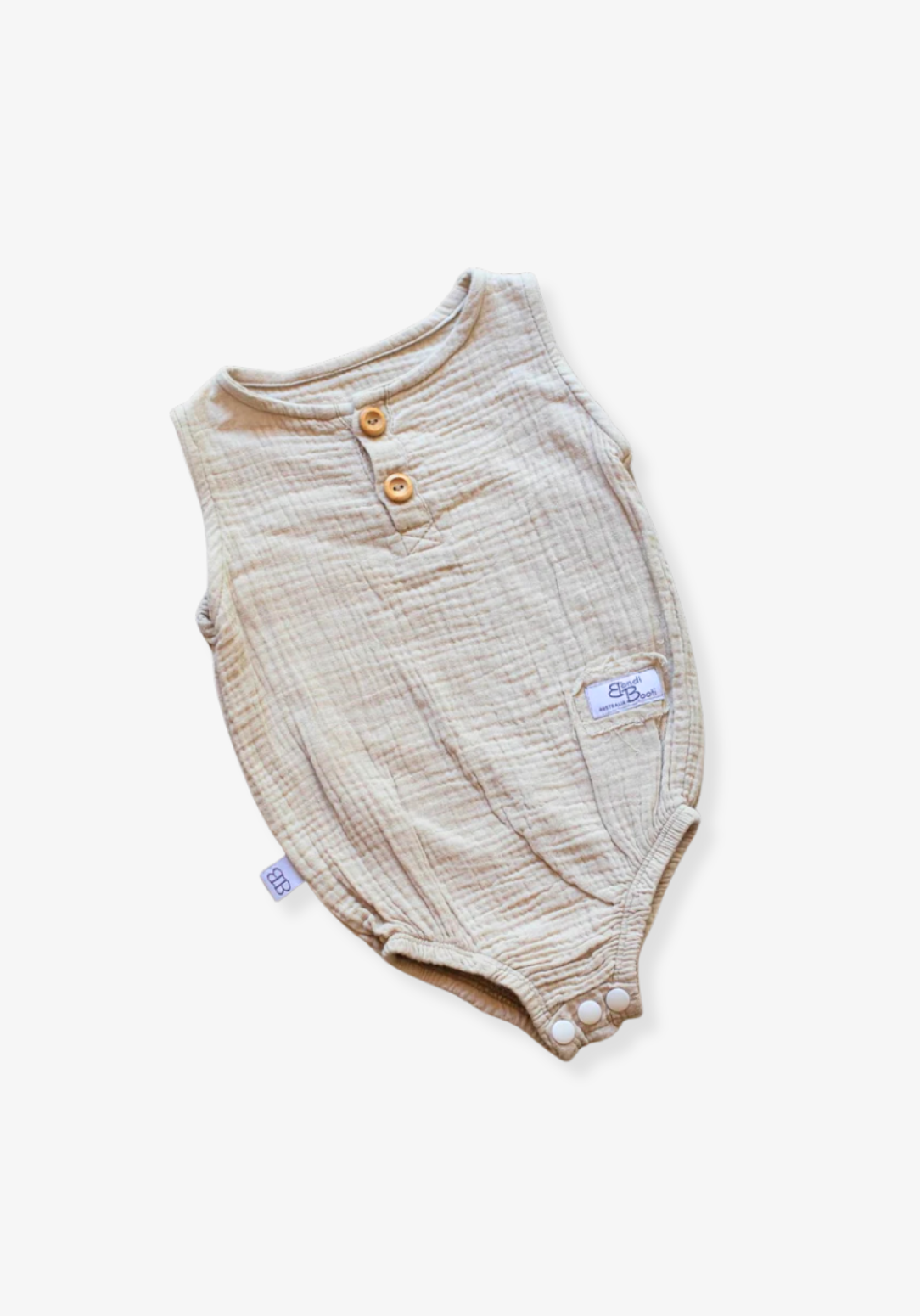 Beige baby romper made of organic cotton with wooden button front and soft texture, displayed on a grey background