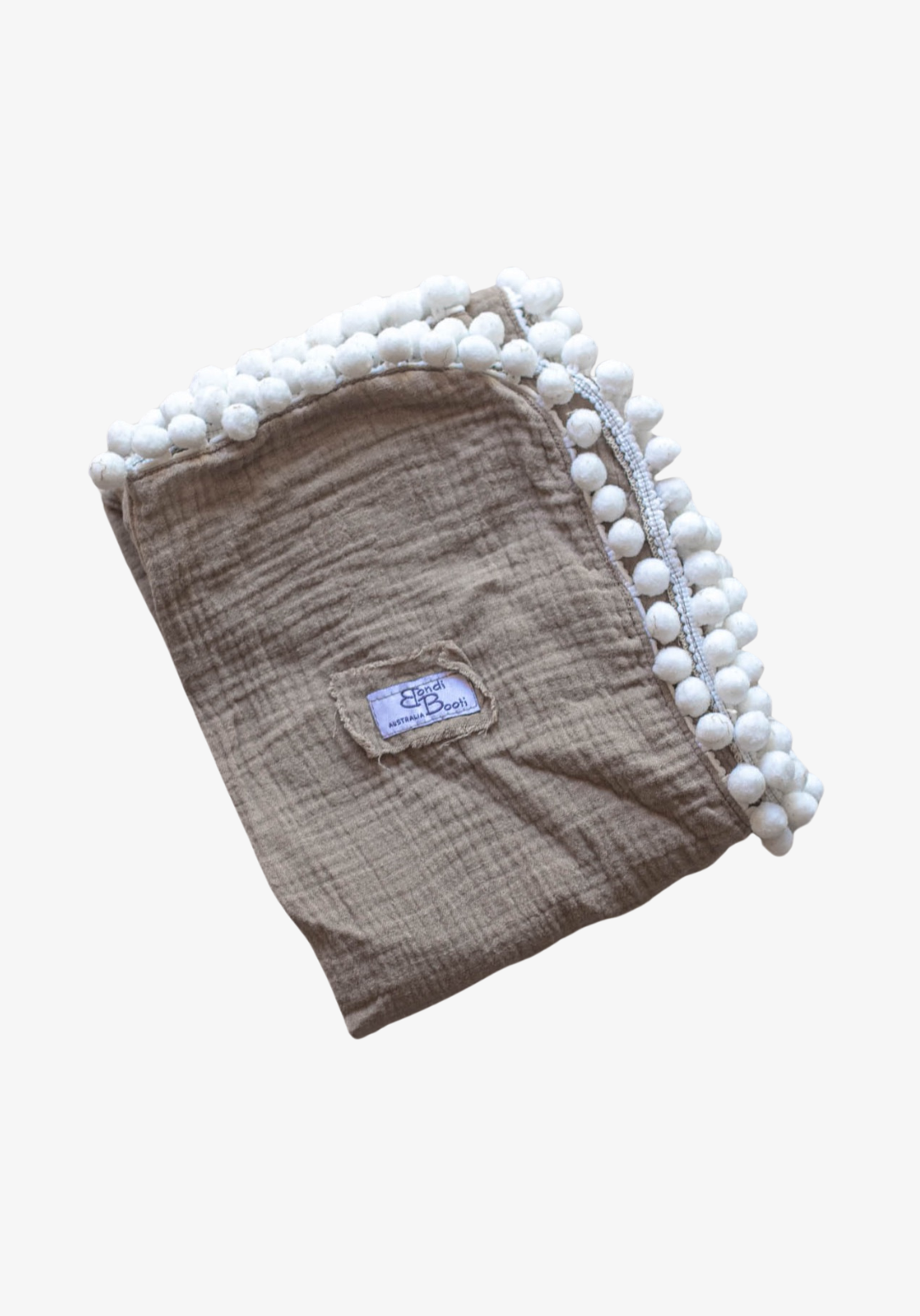 Taupe organic cotton baby blanket with white pom-pom trim, neatly folded with visible Bondi Booti label, displayed on a neutral background.