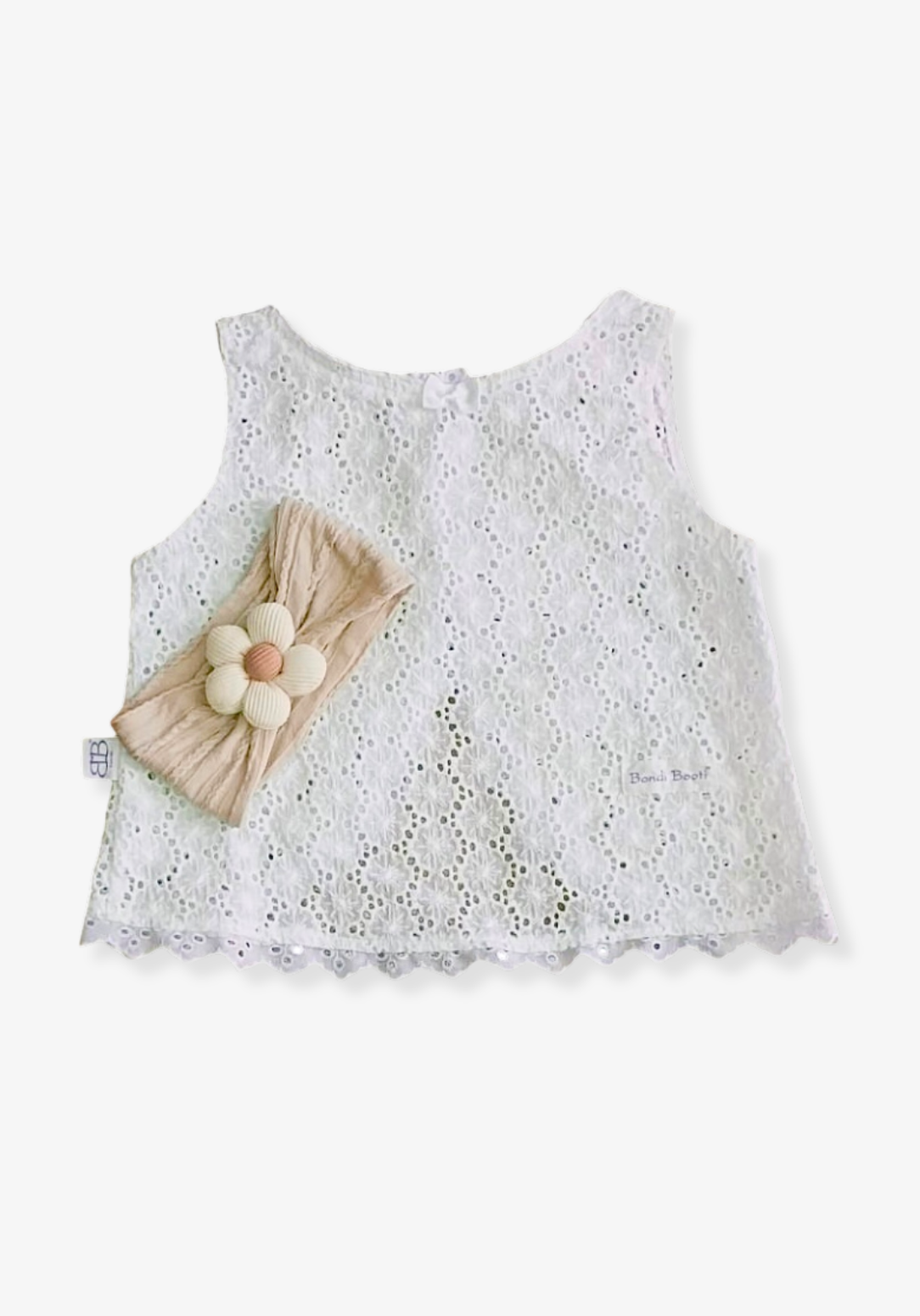 Oat-colored toddler head band with a cream daisy flower sewn at the center.